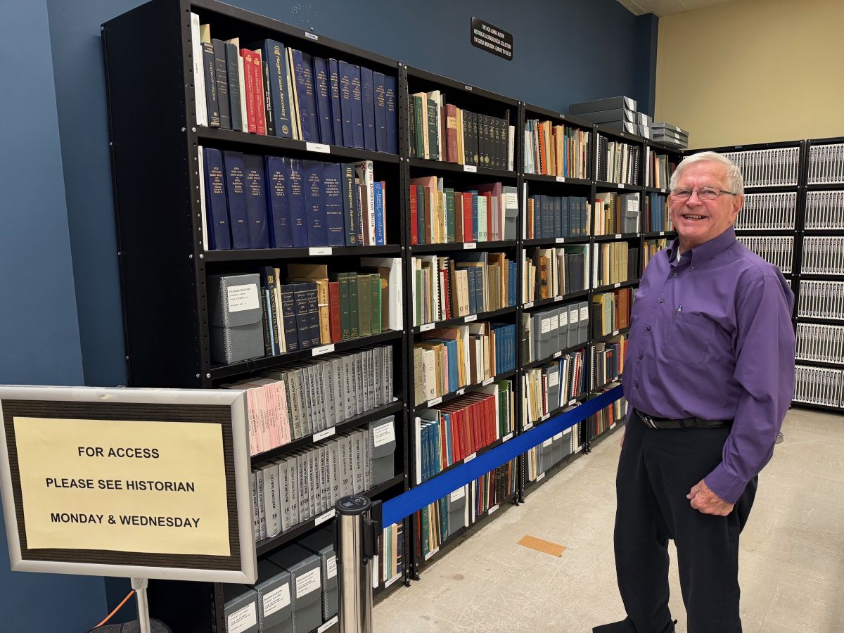 Warren County Historian Dr. Stan Cianfarano with John Austin's history books collection at Warren County Clerk's Office