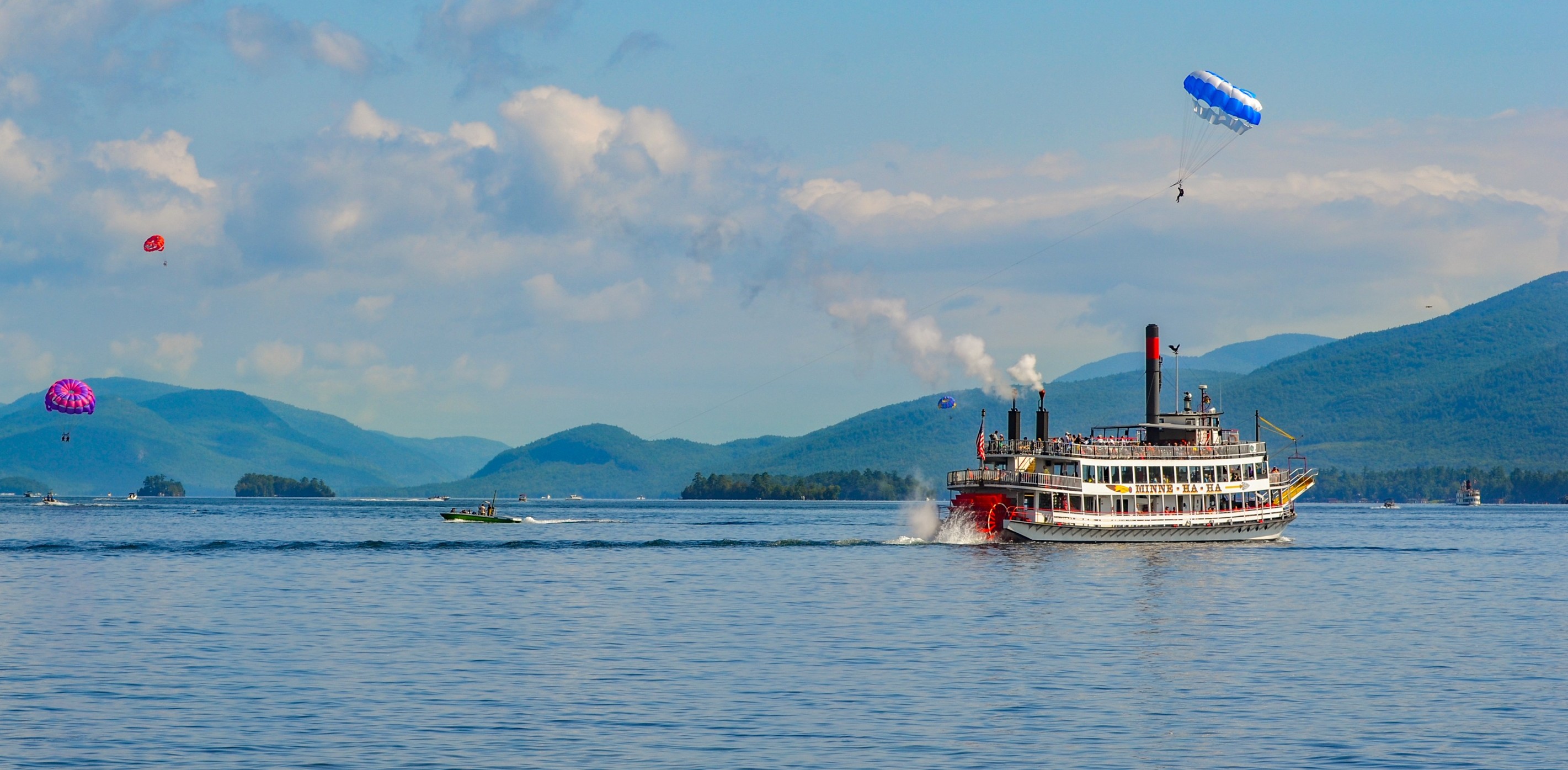 view of lake george tourboat and parasailers