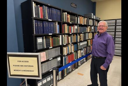 Warren County Historian Dr. Stan Cianfarano with John Austin's history books collection at Warren County Clerk's Office