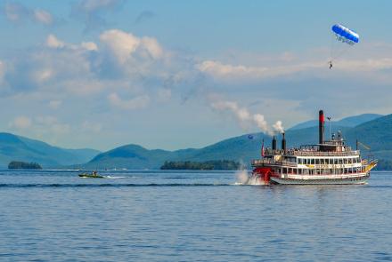 view of lake george tourboat and parasailers